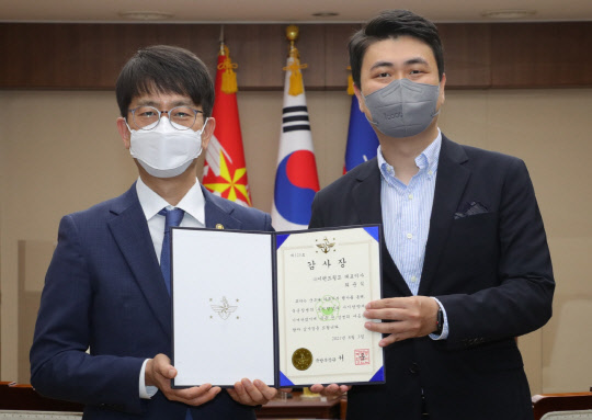 스파오가 국방부장관 감사장을 받았다. 사진은 수여식 후 기념촬영을 하고 있는 박재민(왼쪽) 국방부 차관과 최운식 이랜드월드 대표. <이랜드 제공>